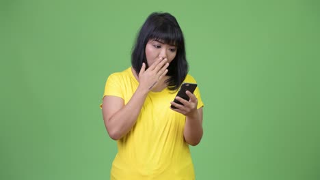 Beautiful-stressed-Asian-woman-using-phone-while-looking-shocked