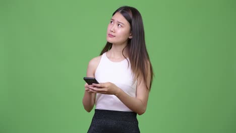 Young-beautiful-Asian-businesswoman-using-phone