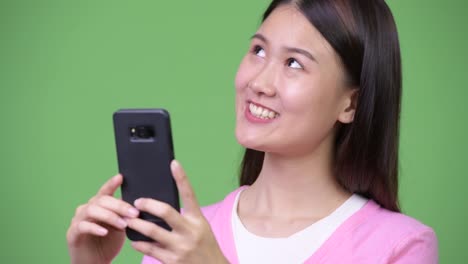 Junge-schöne-asiatische-Frau-mit-Telefon