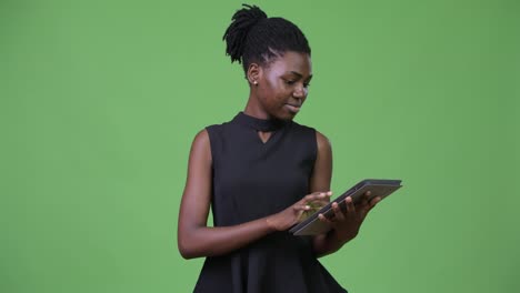 Young-beautiful-African-businesswoman-using-digital-tablet