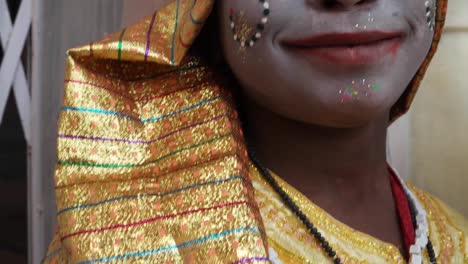 Close-up-handheld-of-a-female-child-dressed-as-a-Hindu-God-wit-makeup-crown-costumes-and-gives-divine-blessings