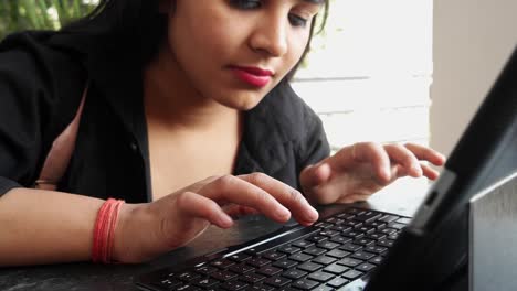 Indian-lady-working-on-a-tablet-with-a-keyboard-computer-at-home-in-Rajasthan,-India