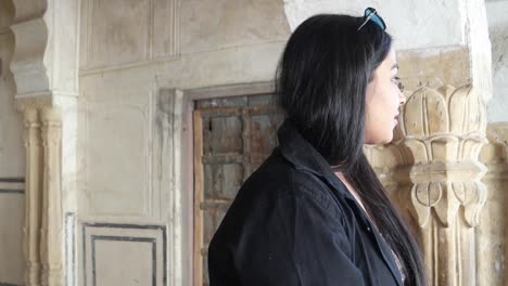 Young-beautiful--Indian-woman-looking-at-camera-and-making-best-of-luck--sign-approve-good-like-it-wonderful-at-an-interior-of-an-Indian-temple-old-building--in-Rajasthan-handheld-closeup-happy-joy