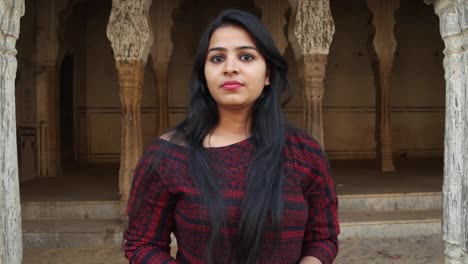 Cute-young-lady-angry-looks-around-smiles-happy-livid-points-finger-straight-at-camera-warns-giving-instructions-order-firing-pissed-lover-POV-handheld-mid-shot-date-late-consequences-at-a-temple