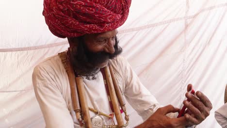 Hand-held-Rajasthani-elderly-male-on-a-smart-cell-phone-mobile-conversation