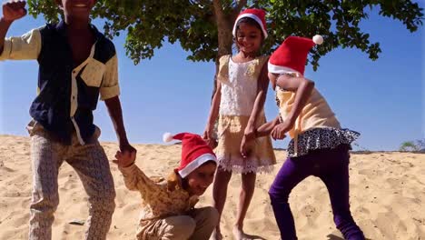 WS-Neigung-bis-zu-Kindern-gehen,-springen-wie-verrückt-verrückt-mit-ihren-Santa-Hüte-in-der-Wüste,-unter-einem-Baum