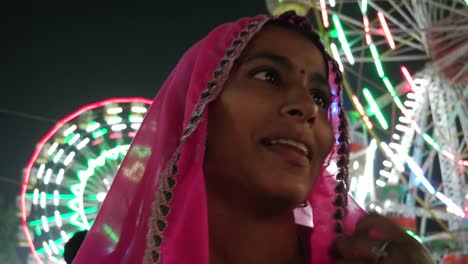 Pareja-tradicional-indio-hablando-en-sari-rosa-y-turbante-rojo-en-Pushkar-Mela,-un-carnaval-de-Rajasthán,-la-India