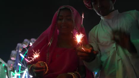 Pareja-India-en-vestido-tradicional-con-fuego-galleta-de-chispa-en-el-festival-de-Diwali-Mela-en-la-India