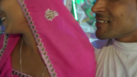 Indian-couple-enjoying-ferris-wheel-ride-in-traditional-dresses-at-the-Pushkar-Mela,-a-carnival-of-Rajasthan,-India