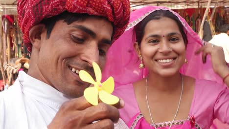 Attractive-Rajasthani-couple-having-fun-blowing-bubbles-and-wearing-ethnic-traditional-Indian-clothing-at-Pushkar-camel-fair,-India