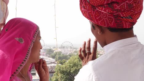 mano-tiro-de-hermosa-niña-y-Compro-viendo-el-carnaval-desde-una-azotea-y-hablar,-India