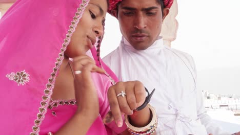 Indian-couple-sharing-a-smart-watch-and-discussing-showing-learning-health