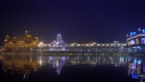 Video-of-Sikh-pilgrims-in-the-Golden-Temple-at-dusk-during-celebration-day-in-December-in-Amritsar,-Punjab,-India.-Harmandir-Sahib-is-the-holiest-pilgrim-site-for-the-Sikhs.