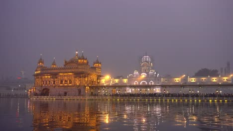 Video-of-Sikh-pilgrims-in-the-Golden-Temple-at-dusk-during-celebration-day-in-December-in-Amritsar,-Punjab,-India.-Harmandir-Sahib-is-the-holiest-pilgrim-site-for-the-Sikhs.