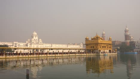 Video-von-Sikh-Pilger-in-den-Goldenen-Tempel-in-der-Abenddämmerung-tagsüber-Feier-im-Dezember-in-Amritsar,-Punjab,-Indien.-Harmandir-Sahib-ist-das-heiligste-Pilgerstätte-für-Sikhs.