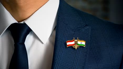 Geschäftsmann-zu-Fuß-in-Richtung-Kamera-mit-Freund-Flaggen-Pin-Österreich---Indien