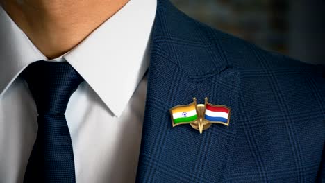 Geschäftsmann-zu-Fuß-in-Richtung-Kamera-mit-Freund-Land-Flaggen-Pin-Indien---Niederlande