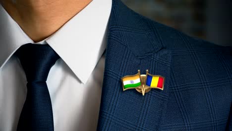 Empresario-caminando-hacia-cámara-con-amigo-país-banderas-Pin-India---Rumania