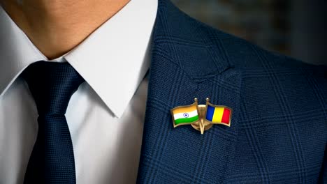 Businessman-Walking-Towards-Camera-With-Friend-Country-Flags-Pin-India---Romania