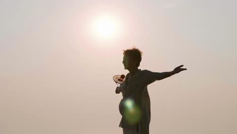 Ältere-Frau-praktizieren-Tai-Chi-Ballon-Ball-am-Strand-bei-Sonnenuntergang