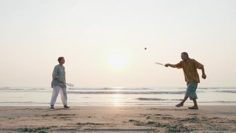 Active-senior-couple-playing-tai-chi-ballon-ball-at-the-beach.