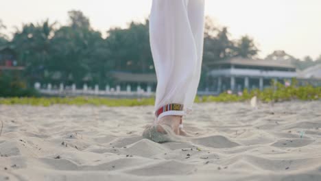 Close-up-feet-of-senior-woman-practicing-tai-chi-on-the-sand