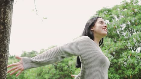 Mujer-atractiva-joven-relajante-en-suéter-gris-en-el-parque-al-aire-libre.-Estilo-de-vida-de-las-personas-libertad