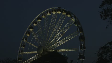 Tilt-down-shot-of-Ferris-wheel-at-night