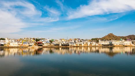 Zeitraffer-auf-die-Heiligen-Ghats-am-Teich-in-Pushkar,-Rajasthan,-Indien,-Heilige-Stadt-für-Hindus.-Bewegte-Wolken-über-Tempel,-Gebäude-und-Ghats.