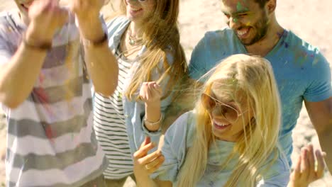 High-Angle-Shot-multi-ethnischen-Gruppe-von-unterschiedlichen-jungen-Menschen-tanzen-und-bunte-Pulver-in-die-Luft-werfen-und-Hände-zur-Feier-des-Holi-fest.-Sie-haben-enorm-viel-Spaß-an-diesem-sonnigen-Tag.