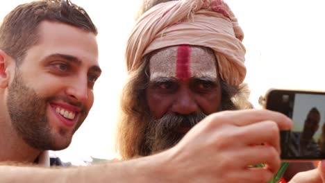 Tourist,-ein-Selbstporträt-mit-Sadhu---heiliger-Mann,-in-Varanasi,-Indien