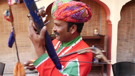 Indischer-Mann-spielt-traditionelle-Musikinstrument-in-Jaipur,-Rajasthan,-Indien