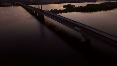 Bridge-with-trafic-over-the-river-at-sunset-aerial-drone-footage
