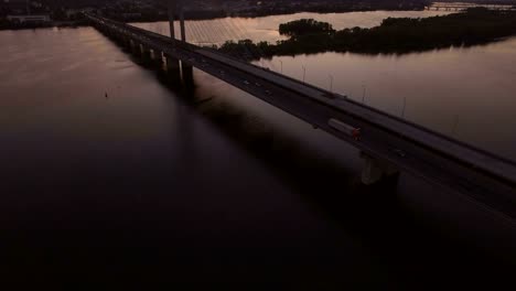 Brücke-mit-Trafic-über-den-Fluss-bei-Sonnenuntergang-Luftbild-Drohne-Filmmaterial