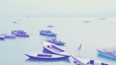 Indian-pilgrims-rowing-boat-in-dawn,-Ganges-river-in-Varanasi,-India.