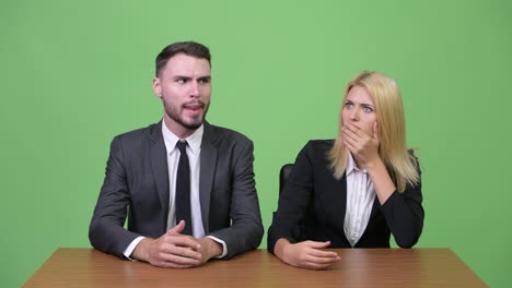 Young-businessman-making-funny-faces-to-young-businesswoman