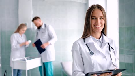 Portrait-female-medical-specialist-with-stethoscope-surrounded-by-working-environment-at-hospital