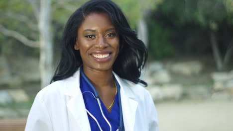 Slow-Motion-of-black-female-doctor-in-white-coat-smiling-at-the-camera