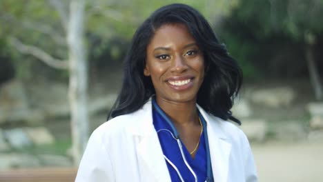 Slow-Motion-of-black-female-doctor-in-white-coat-smiling-at-the-camera