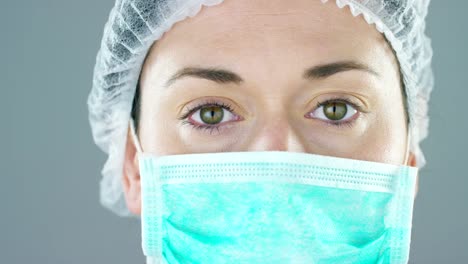 Portrait-of-a-female-doctor-with-white-coat-and-stethoscope-smiling-looking-into-camera-on-white-background.