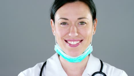 Retrato-de-un-mujer-médico-con-bata-blanca-y-estetoscopio-sonriendo-mirando-en-cámara-sobre-fondo-blanco.