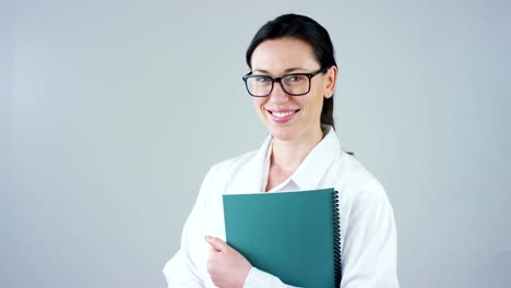 Retrato-de-un-mujer-médico-con-bata-blanca-y-estetoscopio-sonriendo-mirando-en-cámara-sobre-fondo-blanco.