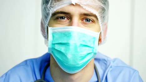 close-up-portrait-of-a-surgeon-or-doctor-with-mask-and-headset-ready-for-operation-in-hospital-or-clinic.-The-surgeon-smiles-safe-and-proud-of-himself.