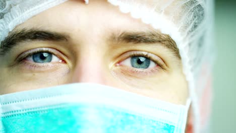 close-up-portrait-of-a-surgeon-or-doctor-with-mask-and-headset-ready-for-operation-in-hospital-or-clinic.-The-surgeon-smiles-safe-and-proud-of-himself.