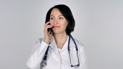 Doctor-de-la-señora-hablando-en-Smartphone,-fondo-blanco