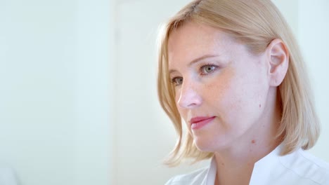 Portrait-smiling-doctor-in-modern-clinic,-colleagues-working.