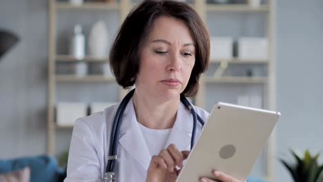 Old-Senior-Doctor-Using-Tablet-for-Browsing-Internet