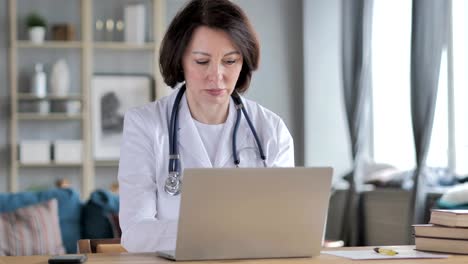 Old-Lady-Doctor-Working-On-Laptop