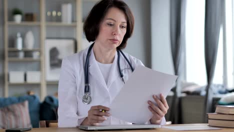 Old-Lady-Doctor-Reading-Medical-Report,-Paperwork