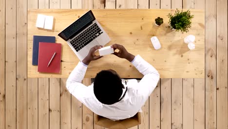 African-pharmacist,-looking-at-box-of-pills